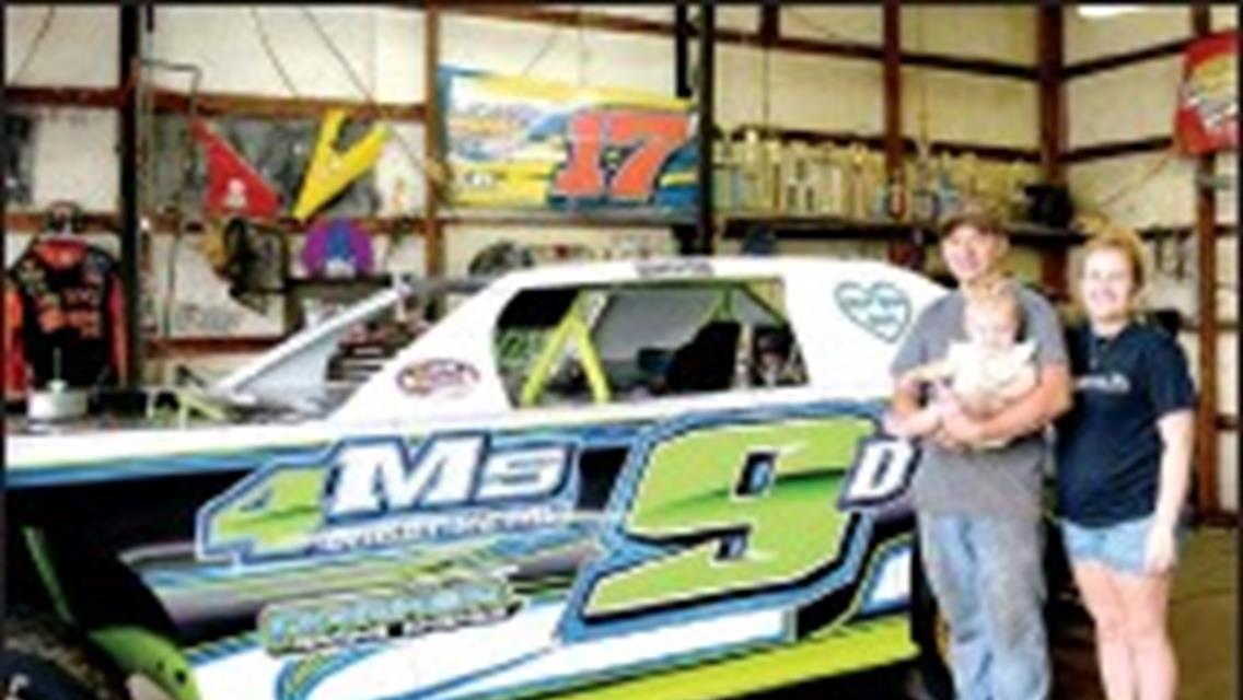 Kyle Davis stood in his garage with his wife, Cheyene and daughter, Callie.